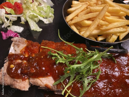 Portion of spare ribs, pork ribs, with barbecue sauce, french fries, salad, on plate, garnished with arugula, food, Stuttgart, Baden-Württemberg, Germany