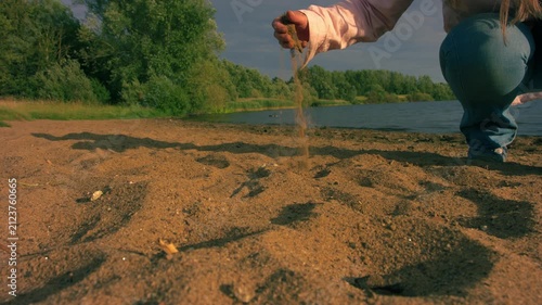 Woman playing with golden sand grains