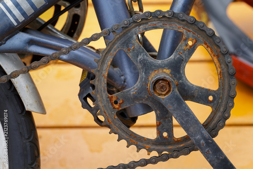 rusty bicycle chainring, crankset, and chain showing corrosion, oxidation, and mechanical wear, bicycle maintenance, neglected drivetrain components, repair needs, rust on cycling equipment