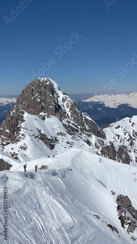 Skiers at the peaks of French alps by winter under snow 