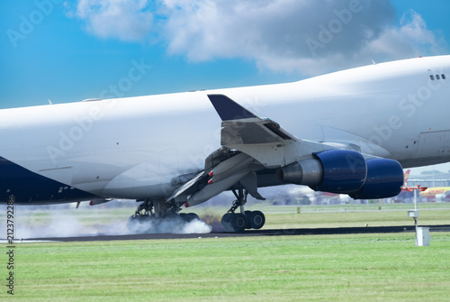  An airplane lands on the runway with Tire Smoke and Hot air is escaping from the engines.
