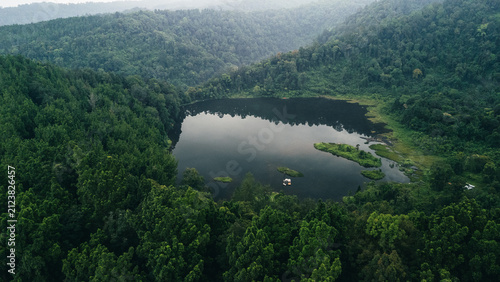 Obraz na plátne Aerial view of a forest lake surrounded by green hills symbolizing peace, balance, renewal, and untouched natural beauty