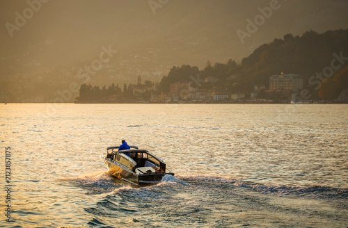 Photography Scenic sunset image of a boat on Lake Como, Lombardy, Italy, Europe