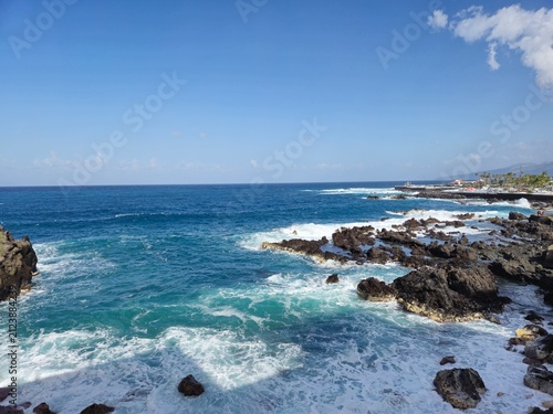 Rocky Ocean Coastline Under Clear Blue Sky