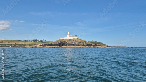 Lighthouse on rocky coastal island above calm sea