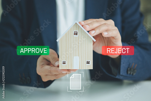 Fotografie Home loan approval with house model business professional reviews property documents to assess eligibility manage lending risk ensure compliance and support secure mortgage decisions