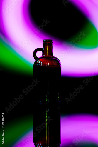 Silhouette of glass bottle with colorful abstract neon light background