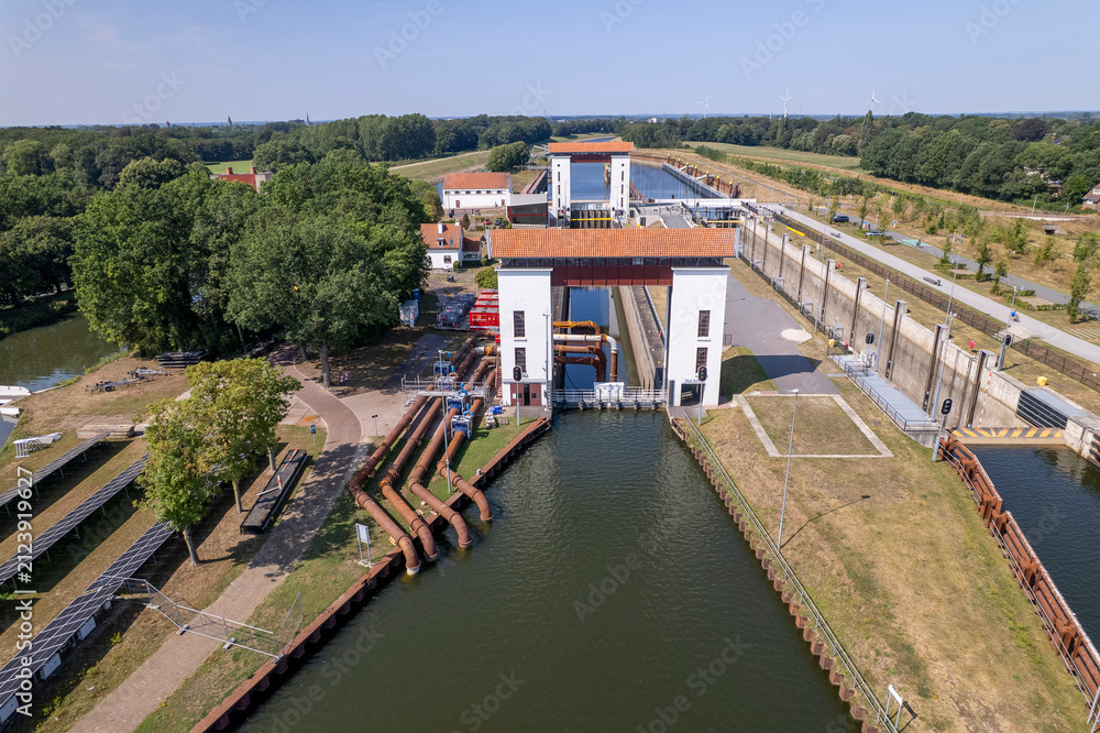 Fototapeta premium Aerial of sluice gate between river IJssel and Twentekanaal in Dutch landscape with water pumping machinery station tubes
