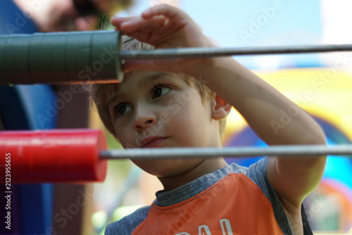 Canvastavla A 3-year-old boy plays in the park, focused on the game pieces.