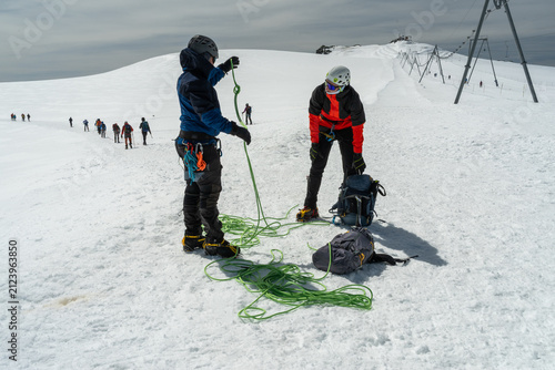 Mountaineers preparing for glacier trekking on a snowy mountain landscape