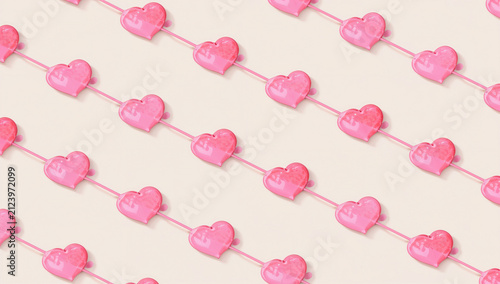 Seamless pattern of pink heart-shaped lollipops arranged diagonally on a light background