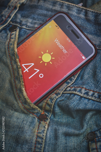 Smartphone Showing Hot Weather Temperature in Denim Pocket