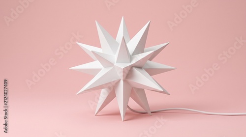 Minimalist white star-shaped table lamp with a geometric Moravian star design, resting on a pastel pink surface with a white textile power cord extending to the right.