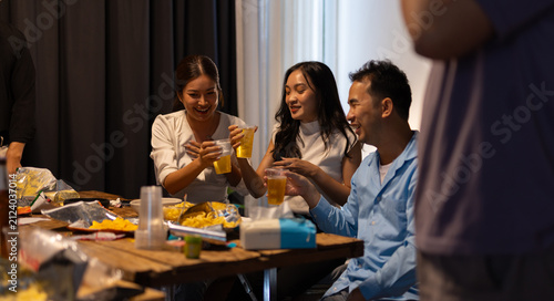 Friends gathering for celebrating party with beer and snacks.