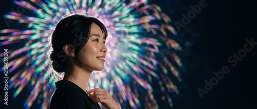 Young Japanese woman enjoying fireworks display at night