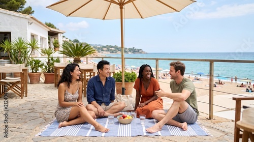 Diverse group of friends enjoying a picnic on a sunny beach terrace