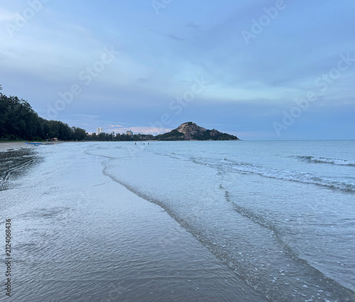 Breathtaking view of a sunset over the calm ocean waves at a tropical beach.