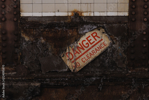 Decayed danger warning sign on grungy wall
