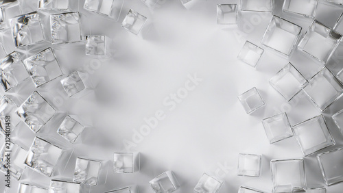 Transparent glass cubes are arranged in a repeating spiral pattern on a bright white abstract Background