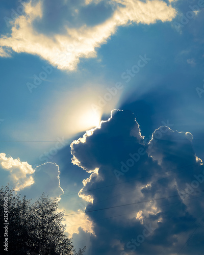 Sunlight breaking through dark cumulus cloud with bright silver lining