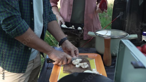 Couple preparing a meal together while camping outdoors