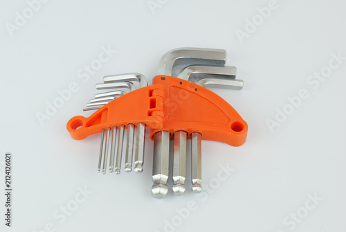 Fotografie Set of metal hex keys in different sizes arranged in a bright orange plastic holder on a light background