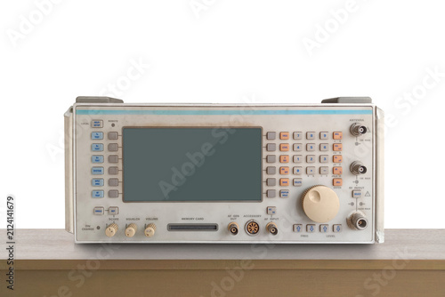 front view old electronic radio communication test set or spectrum analyzer sitting centered on brown wooden floor, white wall background, copy space