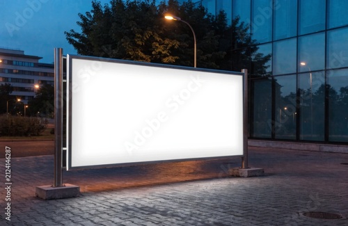 Outdoor billboard mockup, realistic style, illuminated blank advertising display at evening street