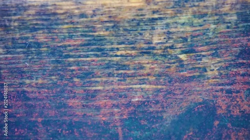 Drippings, drip. The falling drops break on a board made of old wood and form water craters and splashes.