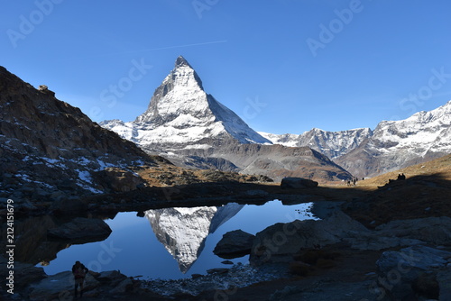 Matterhorn reflected in Riffelsee under a clear blue sky in the Swiss Alps