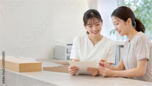 受付で業務を確認する日本人女性スタッフ2人