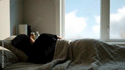 Person sleeping in bed morning light 4K Video