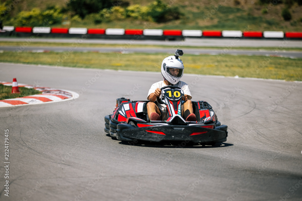 Fototapeta premium High speed go-kart cornering with a teenage driver on an outdoor track