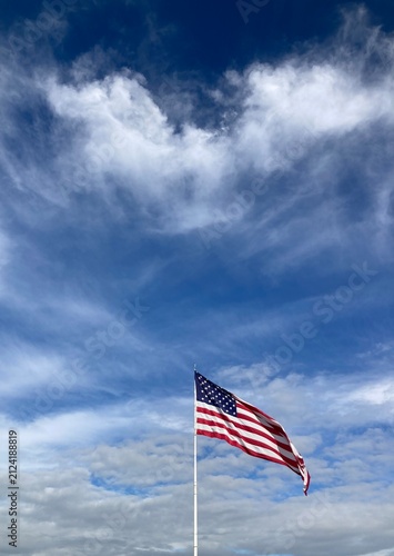 American flag against blue sky and clouds