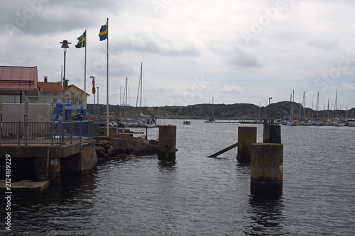 Canvas Print Swedish flags flying over a working harbour in Bohuslan