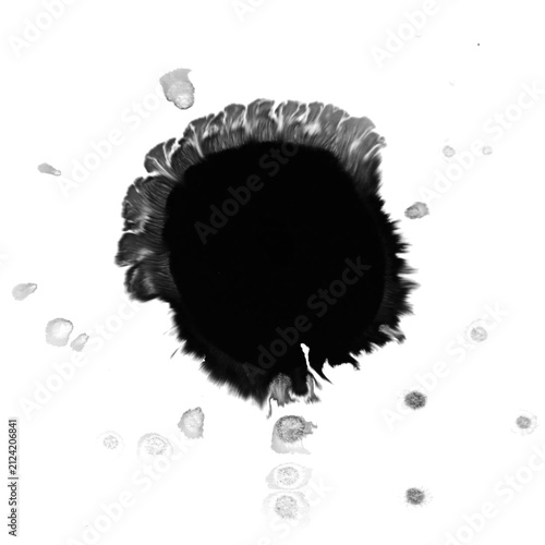 Round black ink blot with feathered brush edge and scattered spray droplets on white