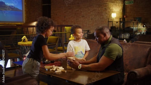Playful Black family enjoying wooden block game