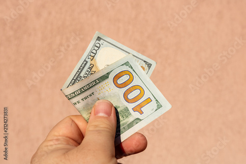 Photography Man hand holding United States Dollar banknotes showing paper texture and symbol
