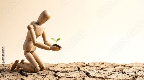 Heat wave climate change and drought risk management concept with wooden figure holding seedling and copy space for presentation banner