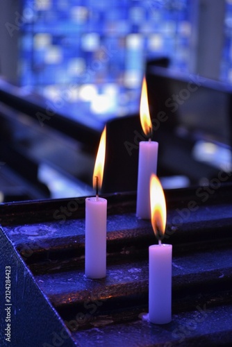 Obraz na płótnie Velas de igreja acesas em um ambiente interno banhado por luz azul