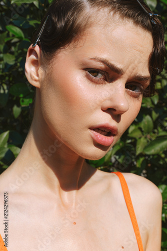 Quadro su tela A woman with natural, real skin in bright daylight, close outdoor portrait showing authentic beauty and imperfect texture, a candid moment of modern female confidence