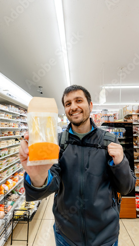Visitor in Tokyo convenience store holding egg sandwich
