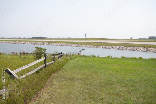 Weathered Wooden Fence Along Calm Lake with Rocky Shore