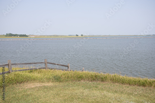 Tranquil Lake View with Wooden Fence and Distant Shore