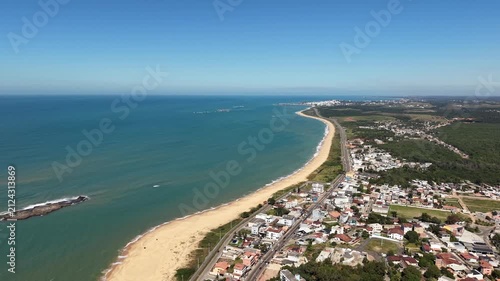 Panoramic aerial drone view of Guarapari, Espírito Santo, Brazil, with tropical beaches, turquoise Atlantic Ocean, urban coastline, rocky shores and mountains in the background.	
