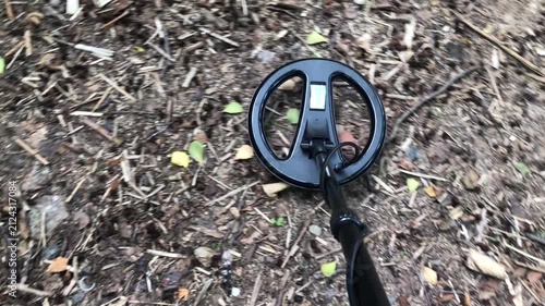 metal detector coil on a rod on the ground in motion