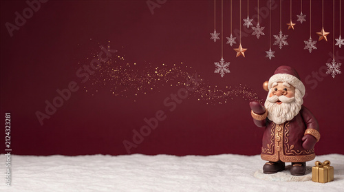 Magical Santa Claus figurine blowing golden stardust on a festive red background with copy space