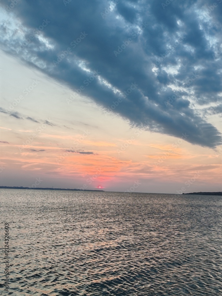 Fototapeta premium Dramatic fan shaped cloud formation over calm Black Sea at sunset
