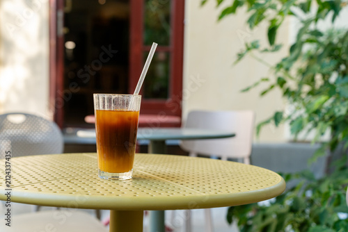 Obraz na plátně Iced bumble coffee and a water pitcher on an outdoor cafe table