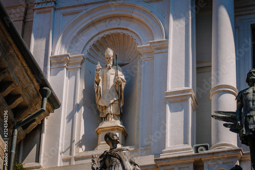 Statue of a religious figure in Cappella Colleoni, showcasing intricate architectural details and surrounding sculptures in Bergamo